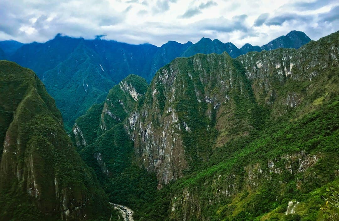Montañas verdes y pardas bajo nubes blancas y cielo azul, en el chat de Megantoni