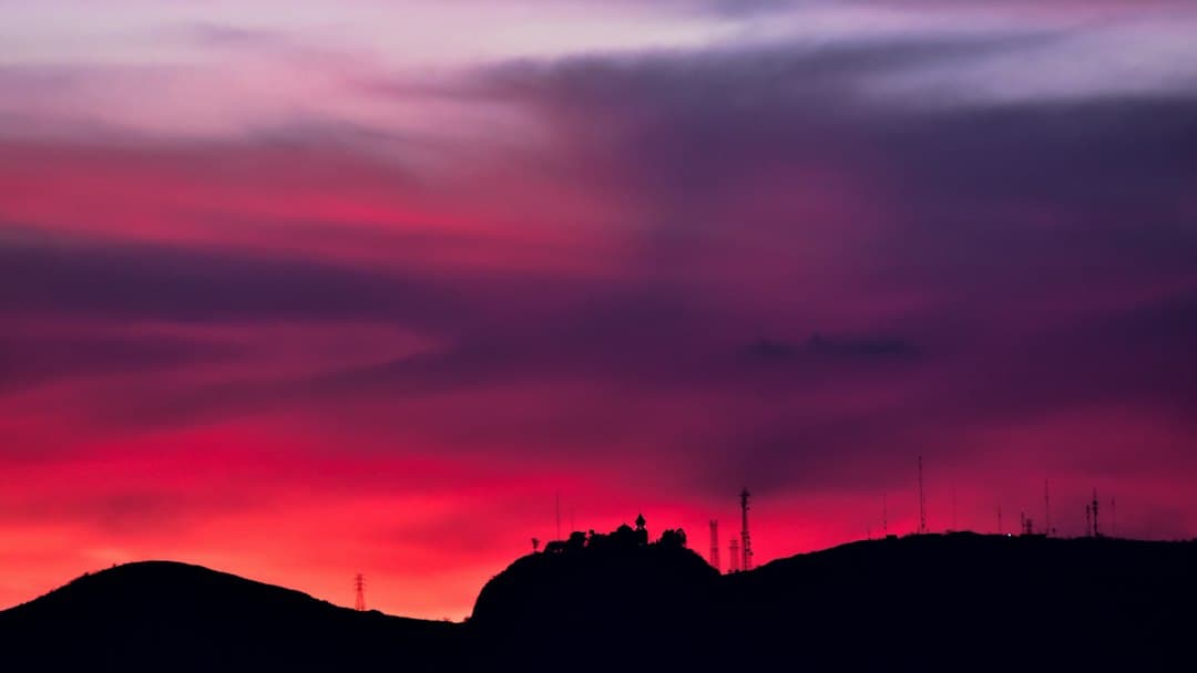 Silueta sobre una roca bajo un cielo morado y rosa, en el chat de Zinacatepec