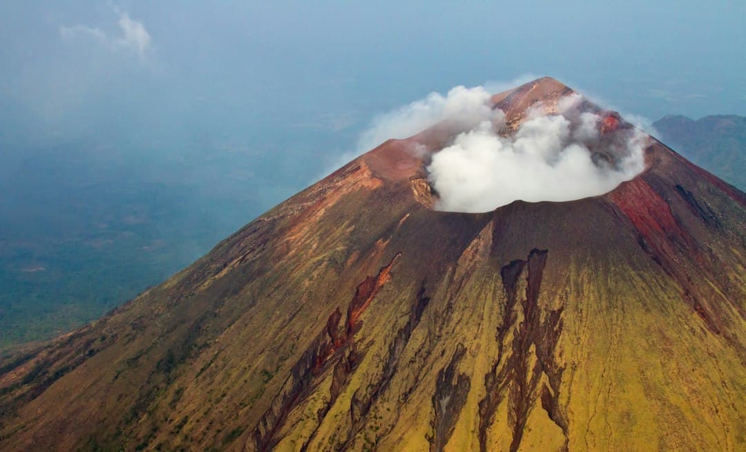Montaña parda y negra bajo el cielo azul de día, en el chat de Posoltega