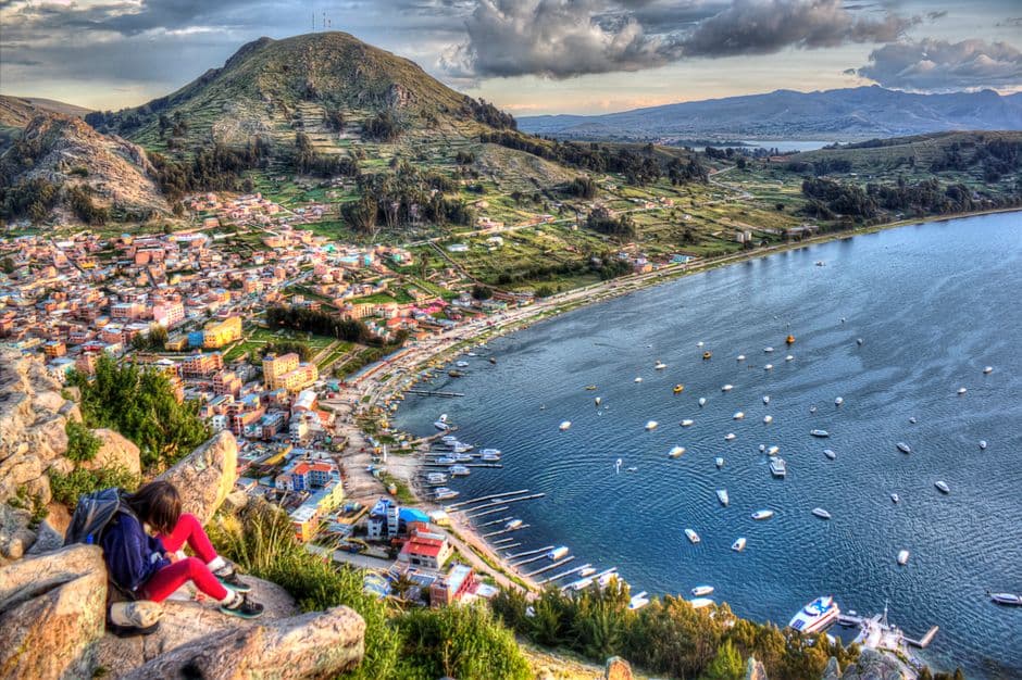 Mujer sentada en lo alto de una montaña con vistas al mar, en el chat de Puerto Quijarro