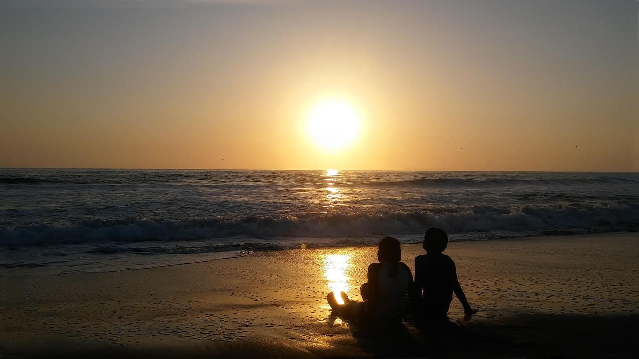 Pareja en la arena de una playa junto al mar, en el chat de Chincha Baja