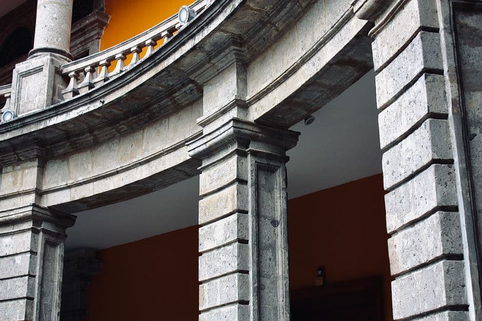 Columnas de piedra bajo cielo azul, rodeadas de vegetación, en la sala de chat de México