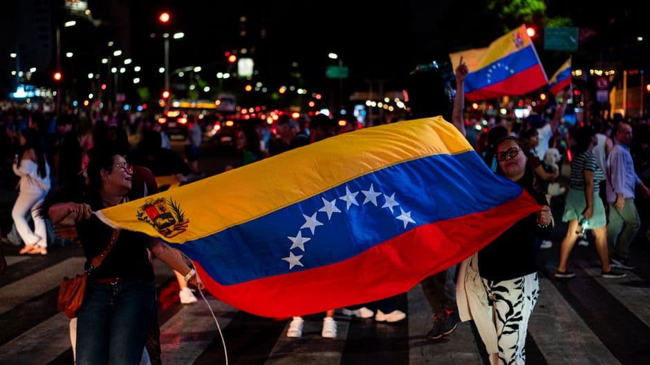 Bandera de Venezuela ondeando bajo luces nocturnas en Buenos Aires, en el chat de Coro