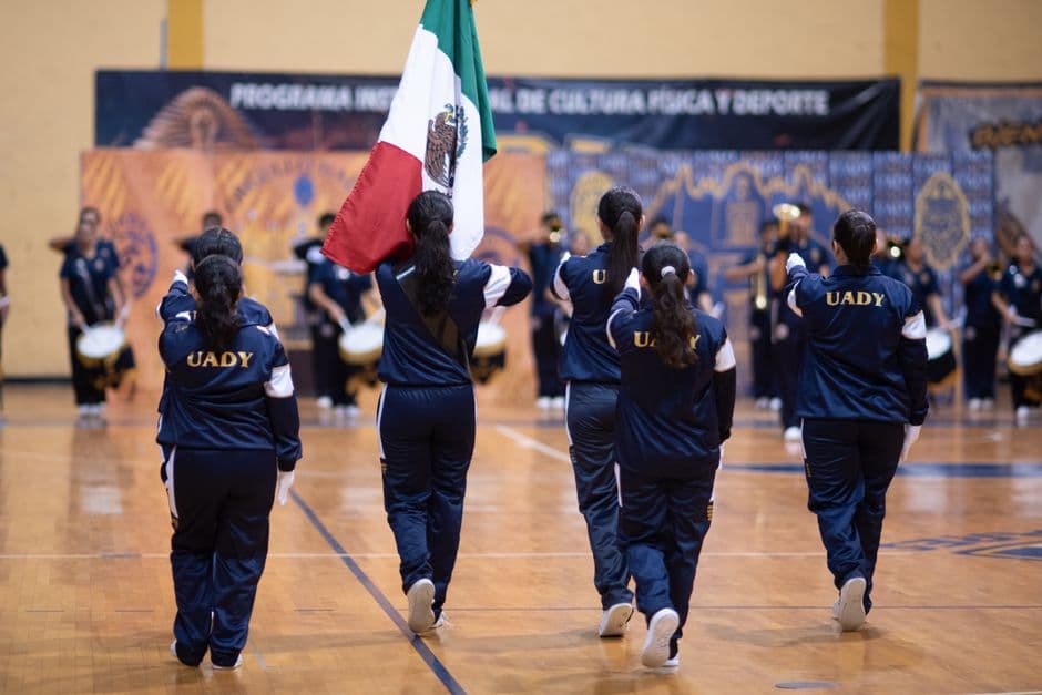 Acto deportivo escolar en México con un abanderado, en el chat de Unión Juárez