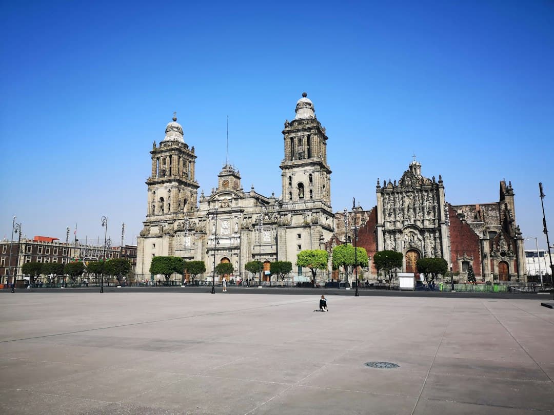 Gente caminando por la acera junto a un edificio blanco de día, en el chat de San Pablo Etla