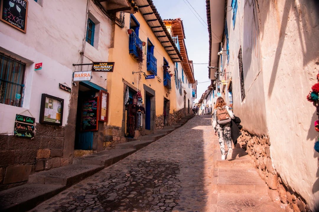 Mujer caminando por una calle entre edificios altos, en el chat de Puquio