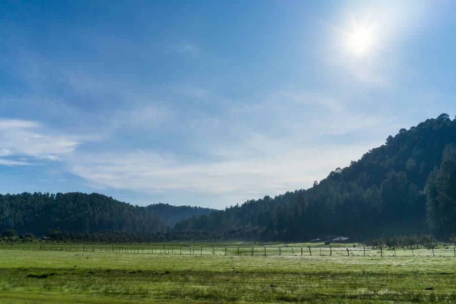 Un valle de montaña tranquilo bajo un cielo azul intenso, en el chat de Erongarícuaro