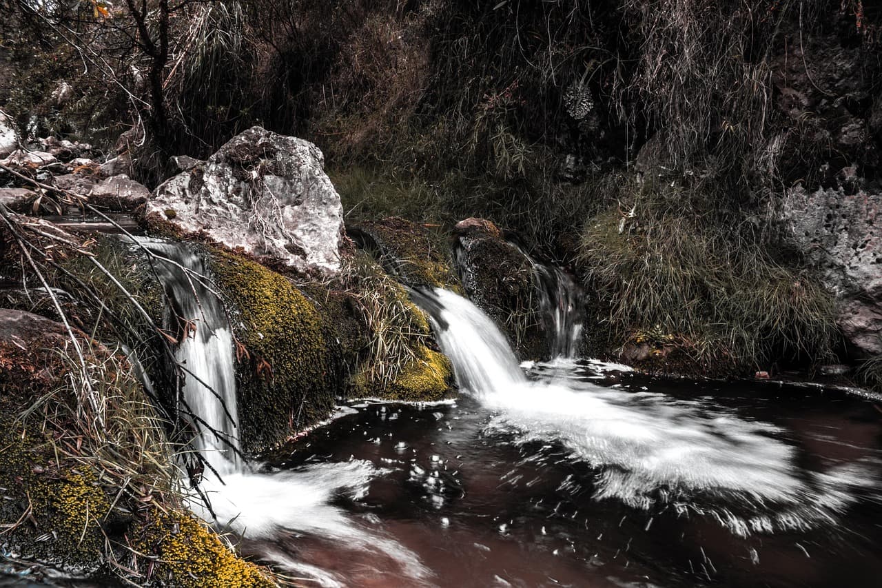 Cascada de río entre rocas cubiertas de musgo, en el chat de Cascas