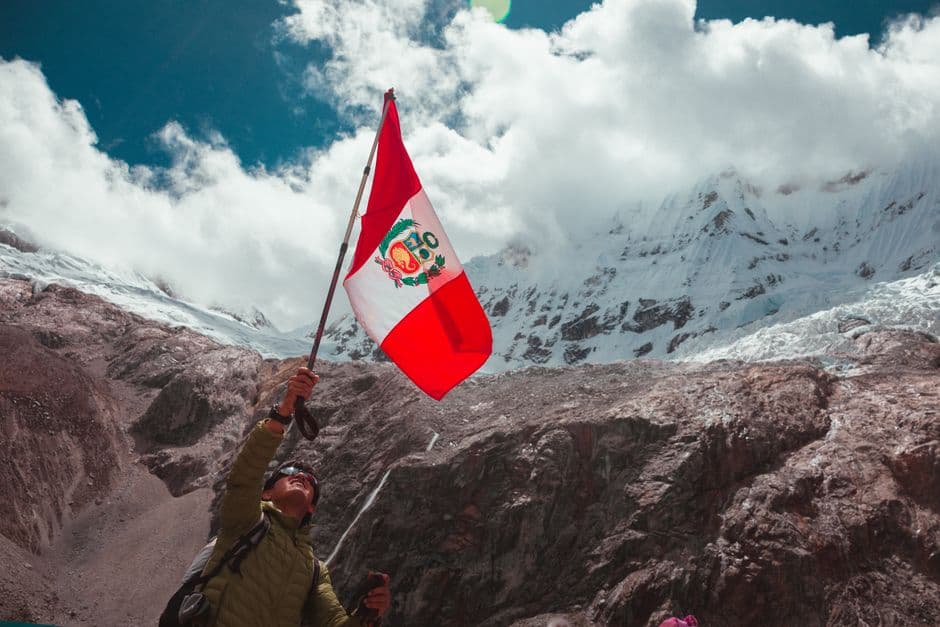 Un hombre con una bandera en la cima de una montaña, en el chat de Ascensión