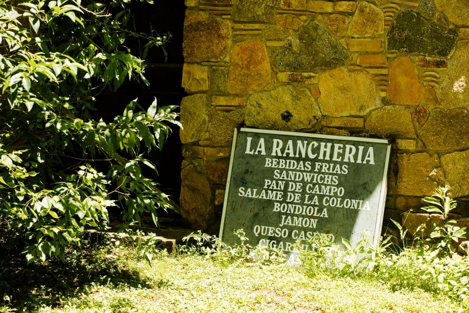Muro rústico de piedra con un cartel en Córdoba, en el chat de La Carlota