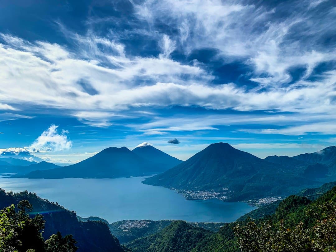 Montañas verdes bajo nubes blancas y cielo azul de día, en el chat de Santo Domingo Xenacoj