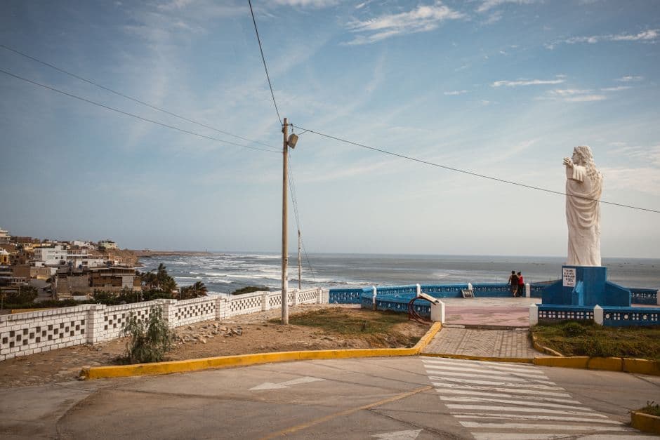 Vista de la costa con una estatua frente al océano, en el chat de San Agustín
