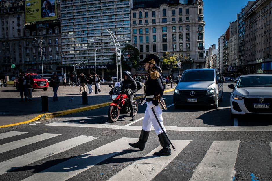 Hombre con traje de época cruzando una calle concurrida, en el chat de Presidencia de la Plaza