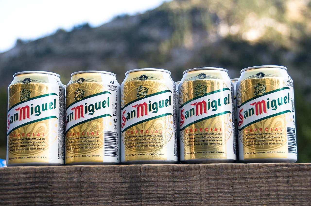 Latas de cerveza San Miguel sobre una mesa, en el chat de San Miguel