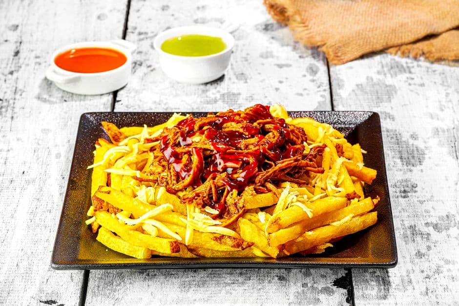 Papas fritas cargadas con cerdo desmechado y salsa barbacoa, en el chat de Patate