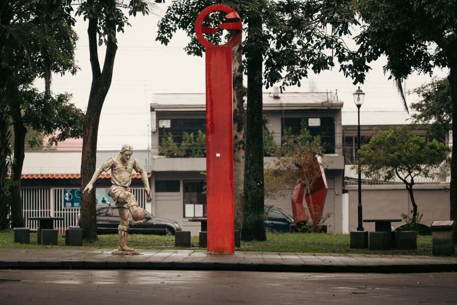 Estatua y columna roja en un parque de Alajuela, en el chat de Puente de Piedra