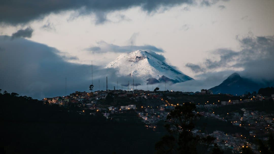 Pueblo iluminado a lo lejos con montañas nevadas, en el chat de San Miguel de Los Bancos