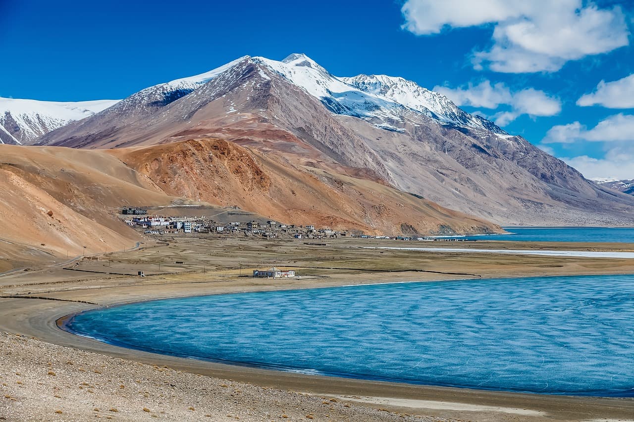Lago de sal brillante rodeado de montañas bajo cielo azul, en el chat de Buena Vista