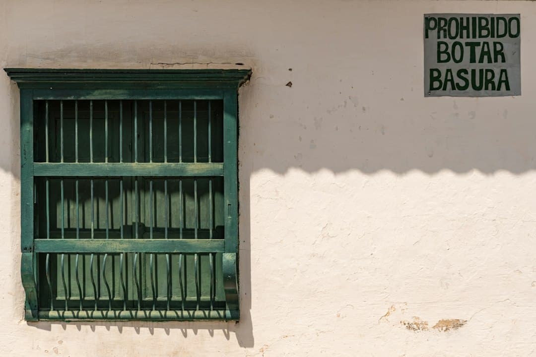 Edificio blanco con una ventana verde y un letrero, en el chat de Chimá