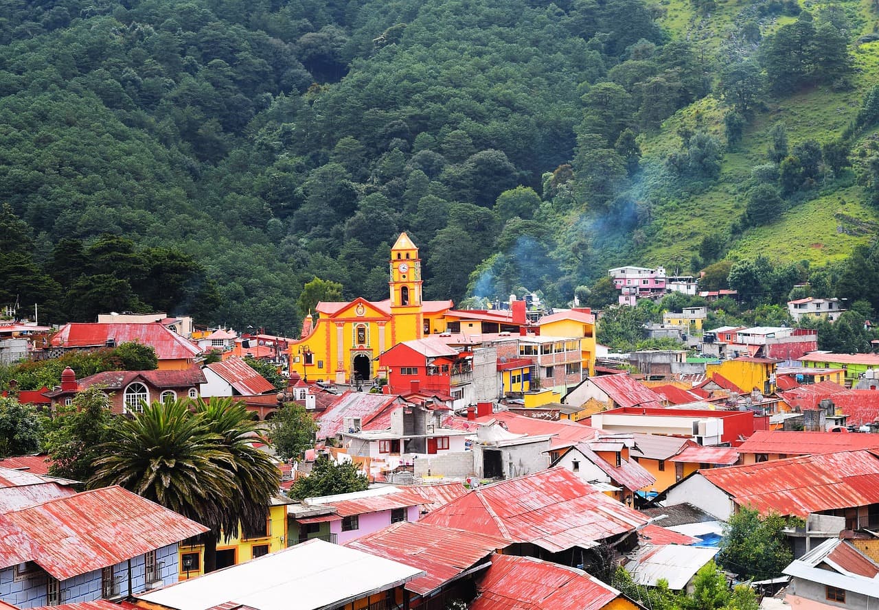 Edificios de un pueblo rodeado de bosque, en el chat de Cadereyta de Montes