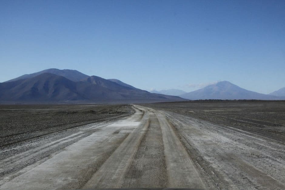 Camino de tierra junto a las montañas bajo el cielo azul, en el chat de Villa Vaca Guzmán