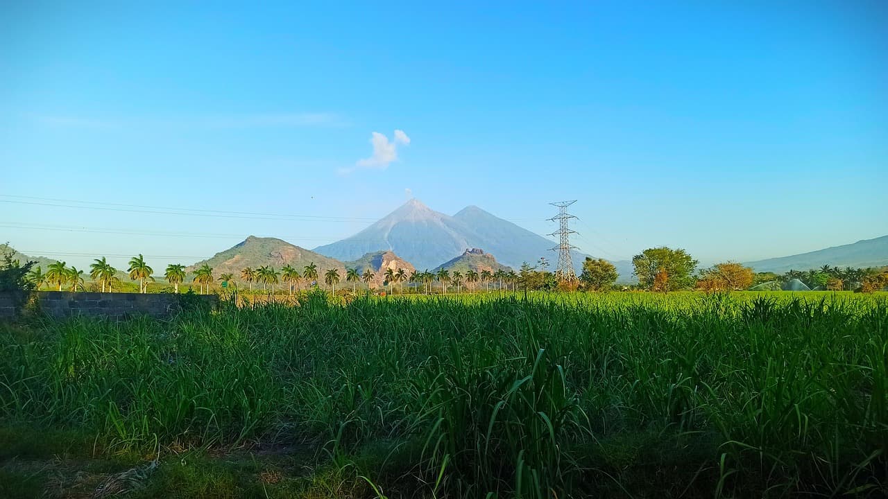 Volcán sobre campos de cultivo y pastos, en el chat de Usumatlán