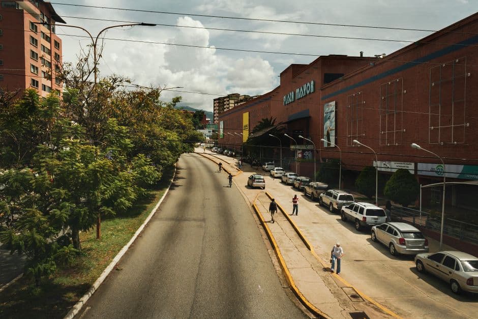 Gente caminando por una calle vacía entre edificios de hormigón, en el chat de Manuel Monge