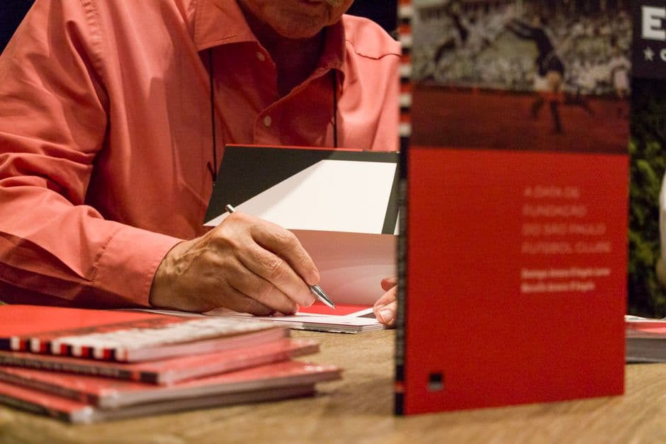 Hombre firmando libros para lectores, en el chat de San Pablo
