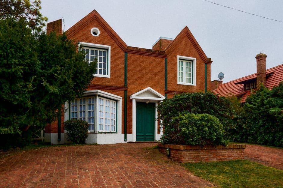 Casa de ladrillo con arbustos y árboles, en la sala de chat de Villa Mercedes