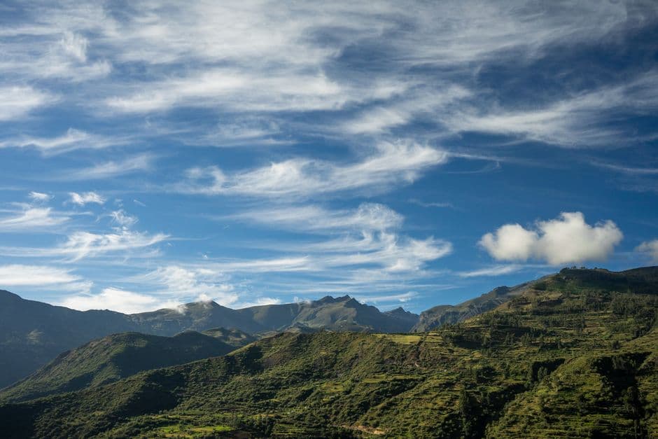 Paisaje de montañas verdes bajo el cielo azul, en el chat de Anccohuayllo