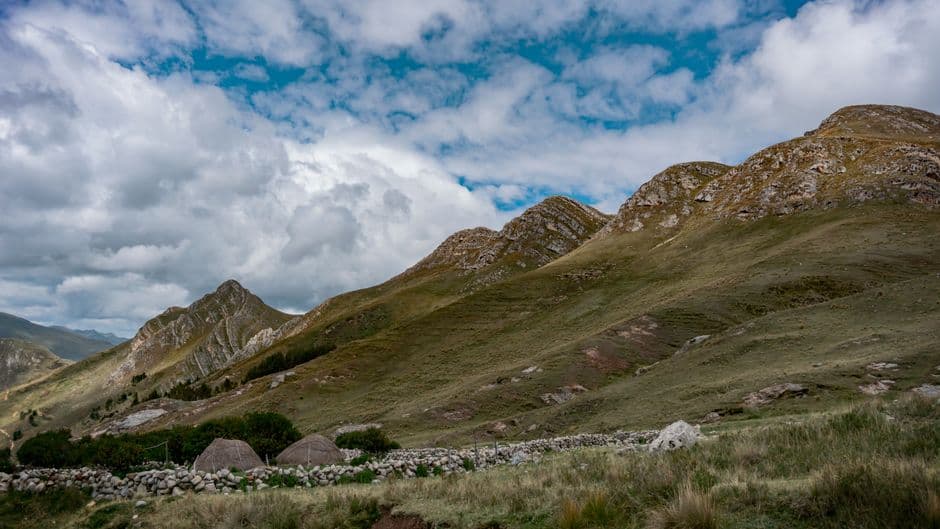 Muros de piedra en un prado junto a montañas, en el chat de San Martín