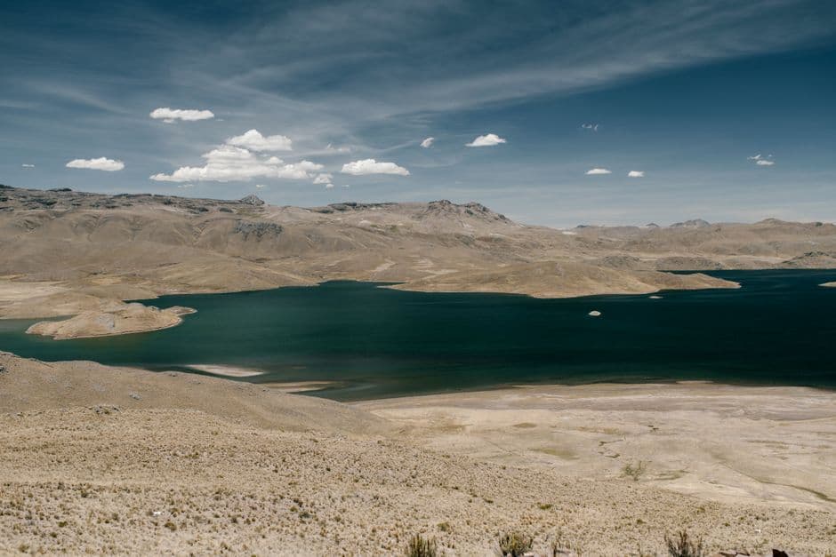 Cielo azul con nubes blancas reflejándose sobre un lago, en el chat de Pocona