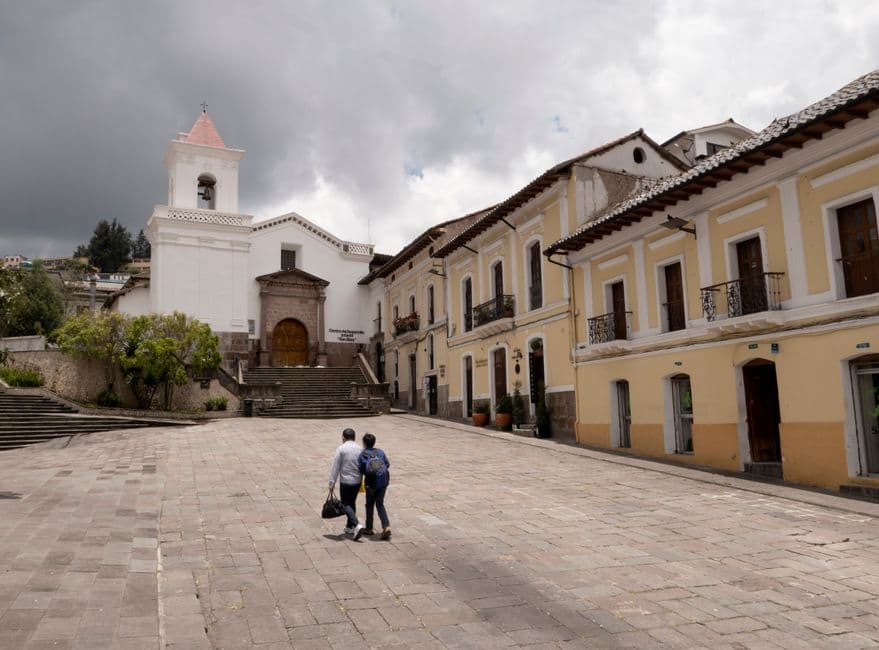 Gente en una plaza junto a la iglesia del pueblo, en el chat de Chordeleg