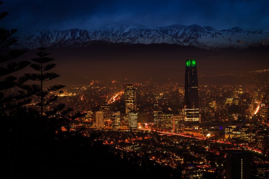 Silhueta de edificios iluminados bajo cielo nocturno, en el chat de Copiapó