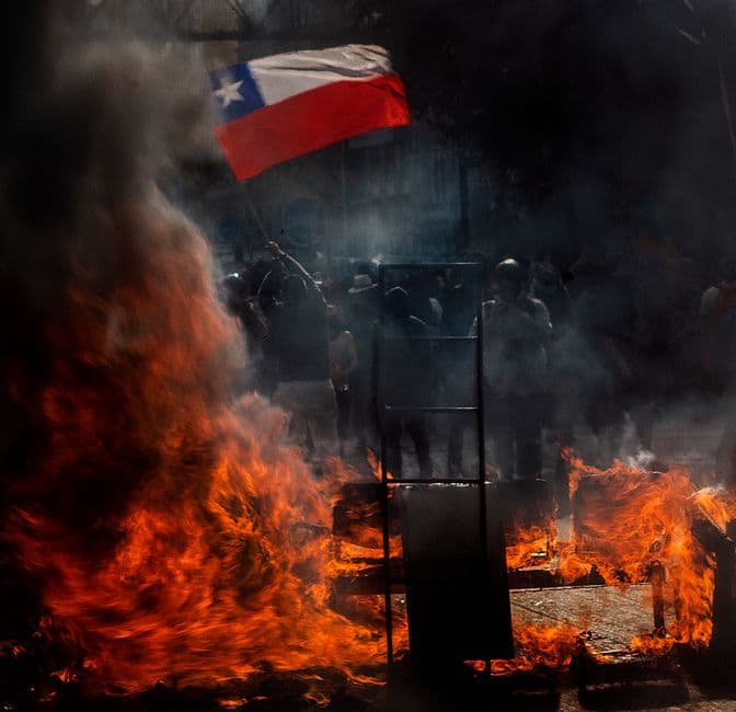 Manifestantes frente a un incendio en la sala de chat de Curicó