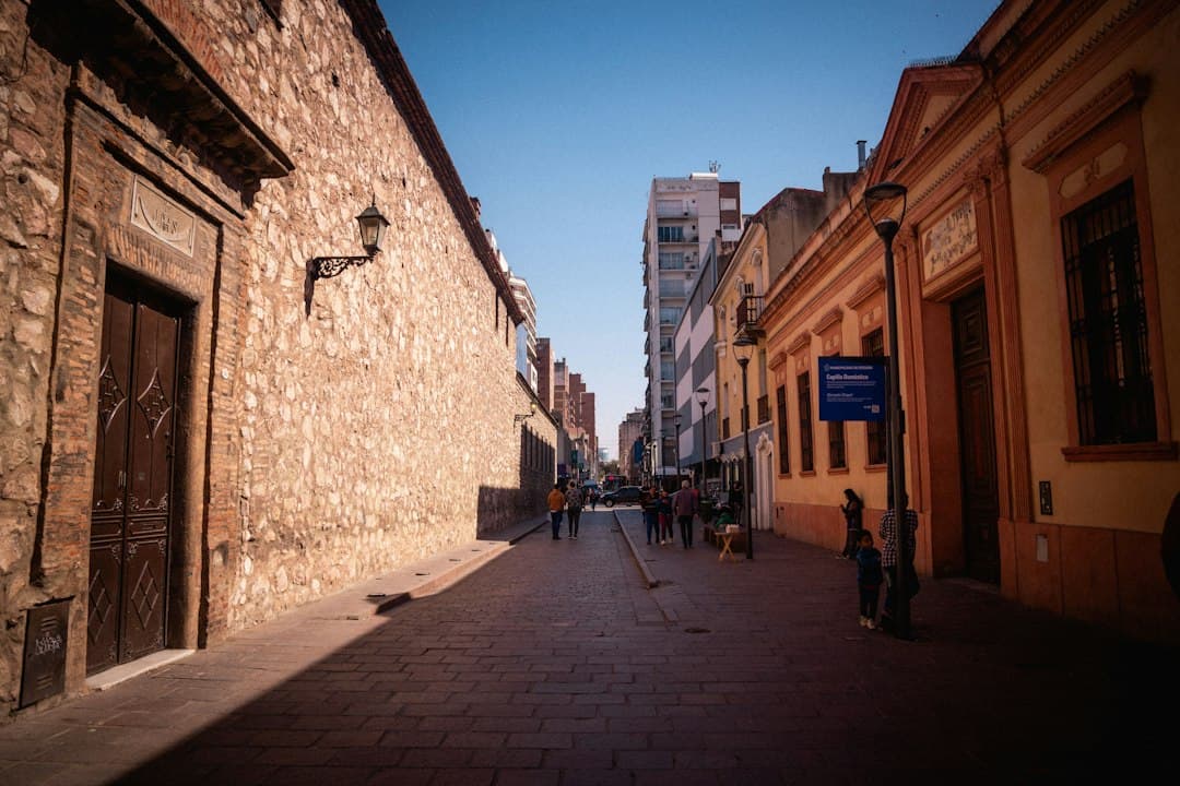 Gente paseando por la acera junto a un edificio de día, en el chat de Apolinario Saravia