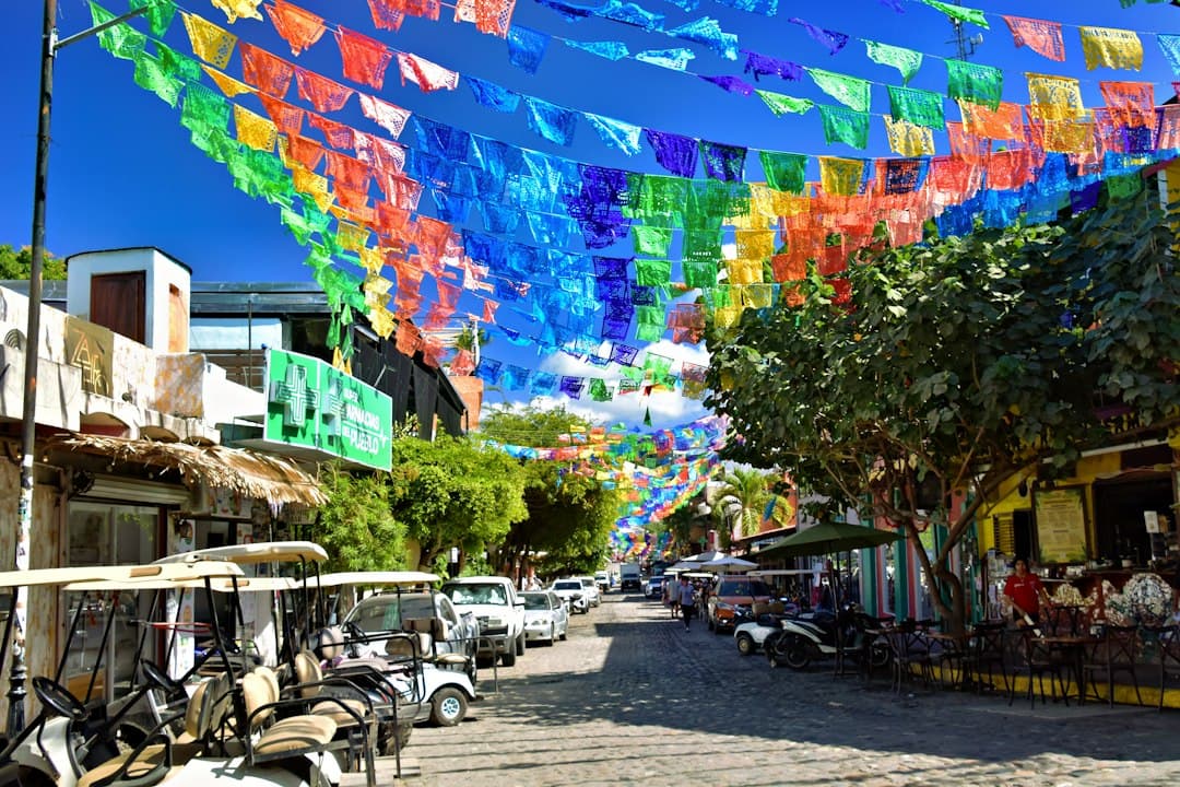 Banderines de colores sobre una calle soleada con carritos de golf, en el chat de Mixtla de Altamirano