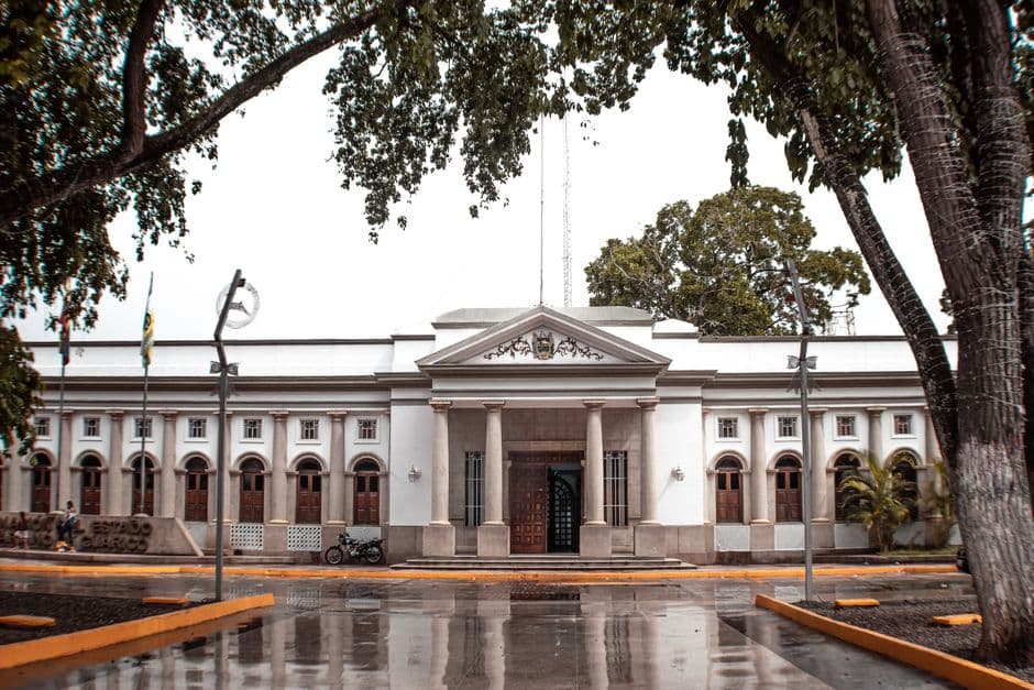 Edificio colonial bajo la lluvia con calles mojadas y faroles encendidos, en el chat de Guaribe