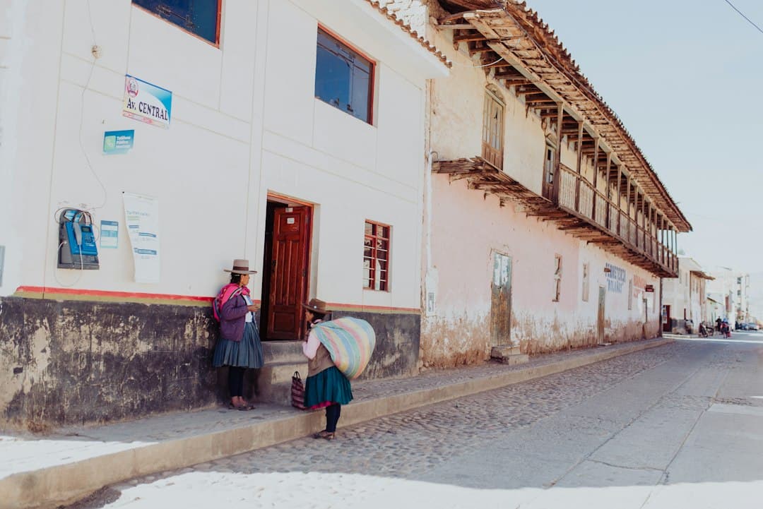 Dos mujeres conversando junto a un edificio de día, en el chat de Yanahuanca