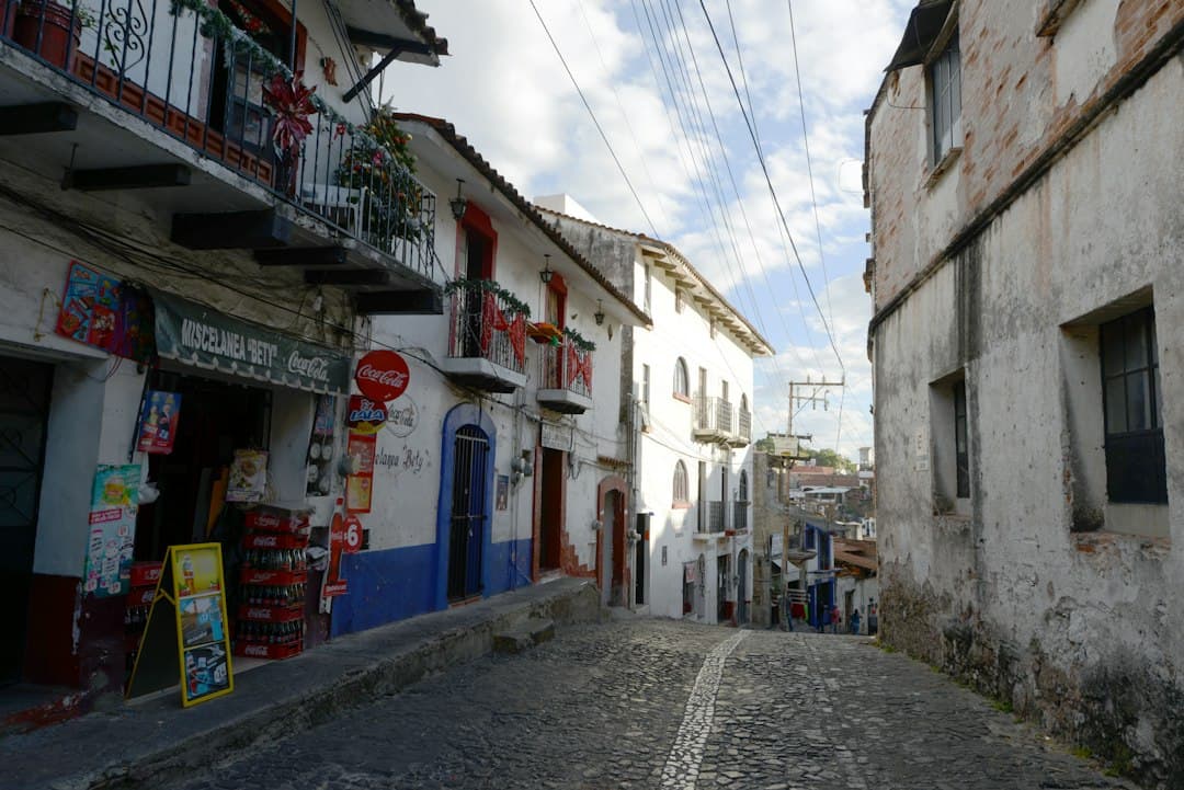 Calle empedrada que sube entre edificios antiguos, en el chat de Ahuazotepec