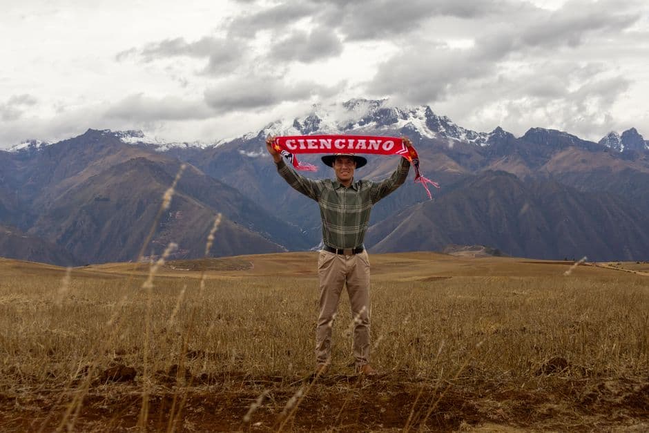 Hombre con una bufanda de fútbol en un paisaje andino, en el chat de Miguel Checa