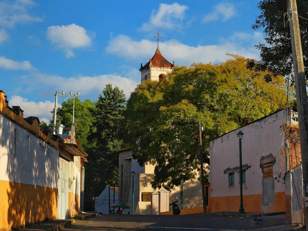 Torre de iglesia sobre una calle tranquila, en el chat de Texcatepec