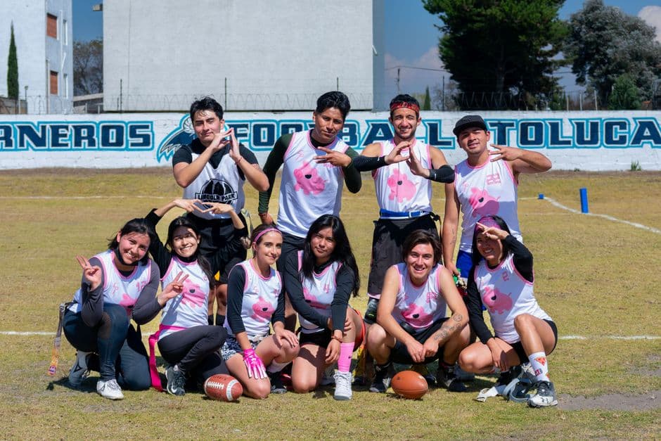 Equipo de fútbol americano juvenil posando en un campo, en la sala de chat de Huixquilucan