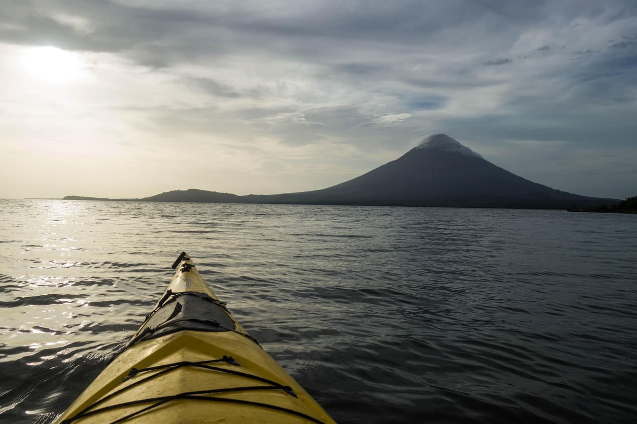 Kayak deslizándose sobre lago al atardecer con reflejo dorado, en la sala de chat de Acoyapa