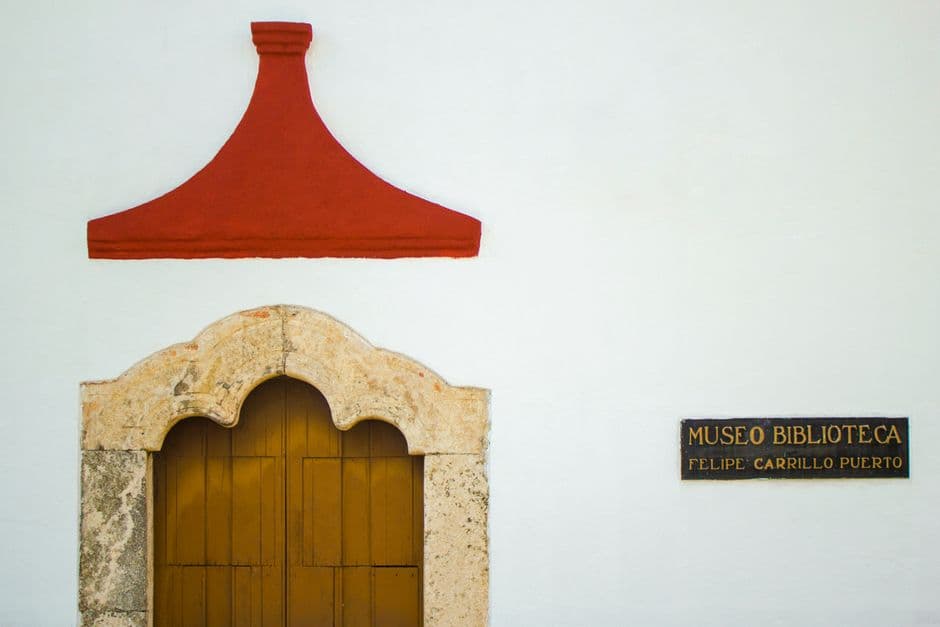 Fachada de un edificio mexicano con una vieja puerta de madera al sol, en el chat de San Felipe Teotlalcingo