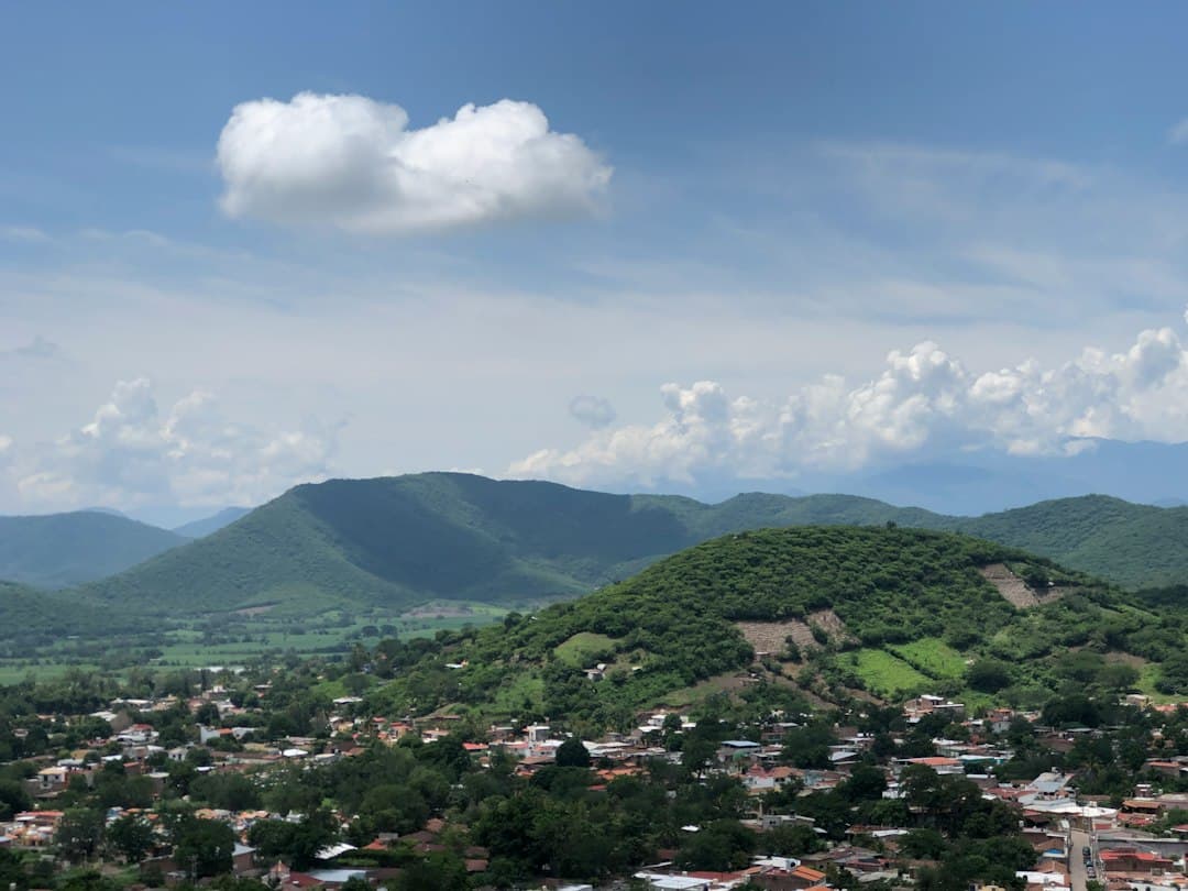 Colinas verdes sobre un pequeño pueblo bajo el cielo azul, en el chat de Chavinda
