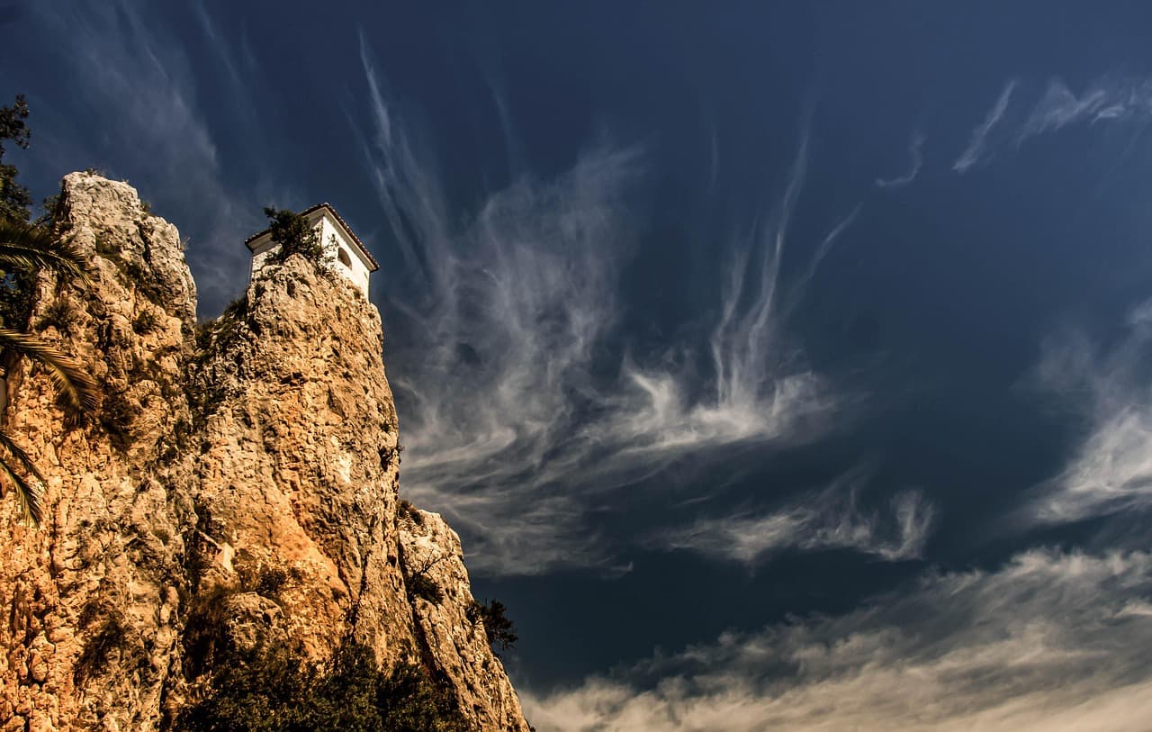 Montañas rocosas con un castillo y una iglesia antigua, en el chat de San Miguel de El Faique
