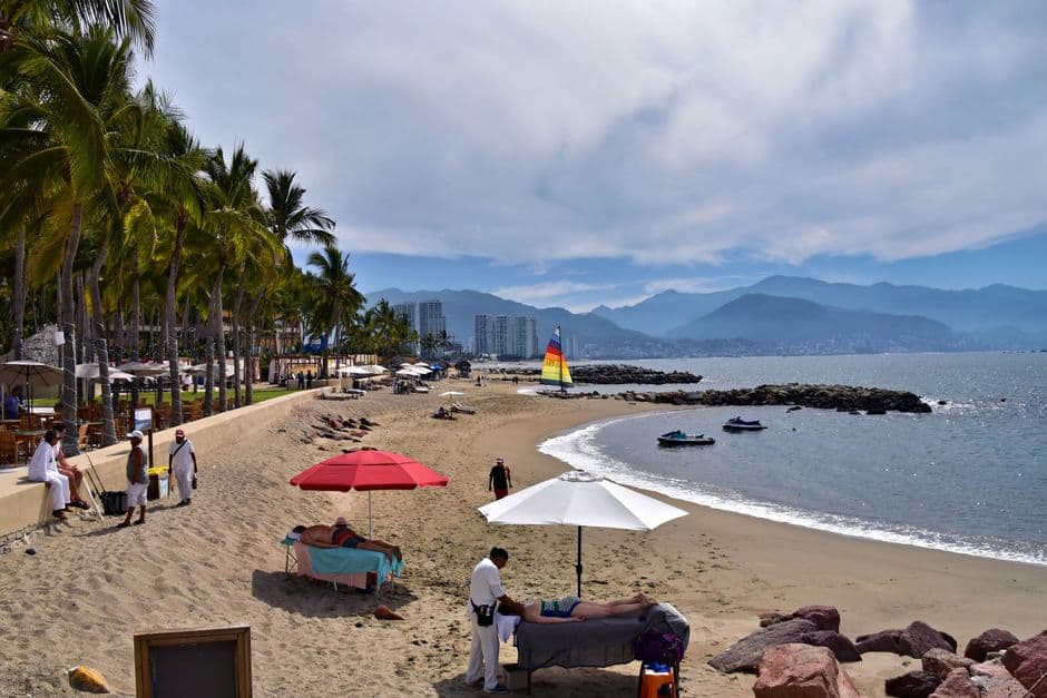 Playa tranquila con palmeras y mar azul, en el chat de Puerto Vallarta