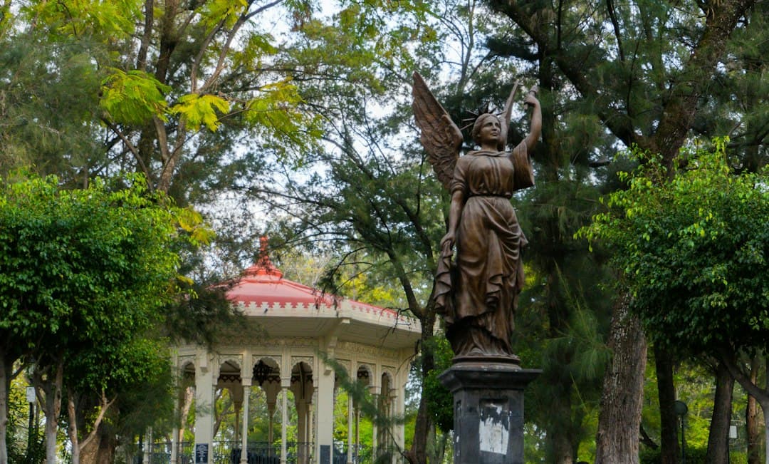 Estatua de una mujer con un pájaro en un parque, en el chat de Celaya