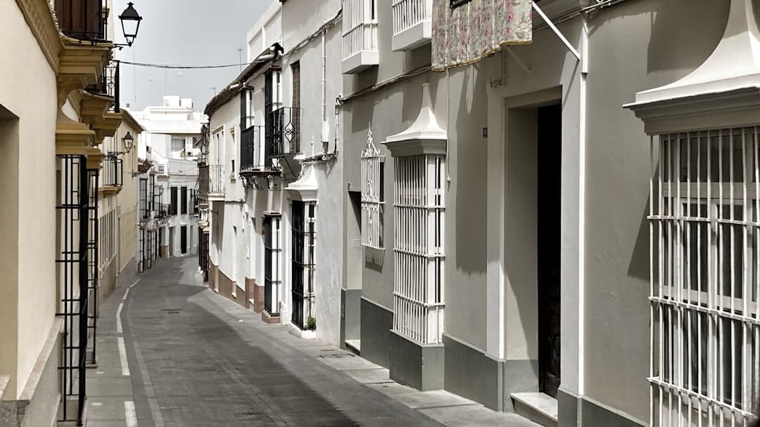 Edificio de concreto blanco bajo el sol, en la sala de chat de Utrera
